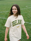Load image into Gallery viewer, Ireland World Champion design with green and gold text, winged shamrock symbol -- garment-dyed tee by Aftercolor | wizarding graphic tee
